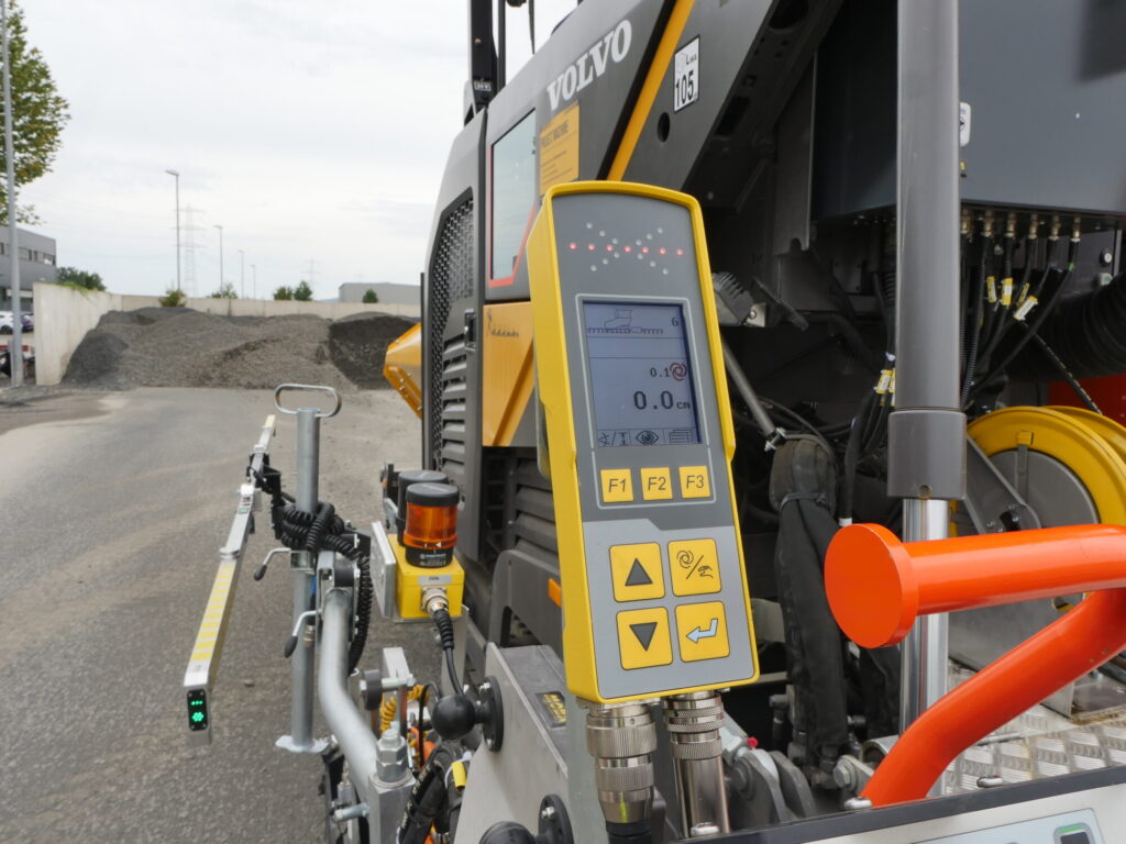 Máquina de pavimentação de asfalto Volvo em operação na construção de uma estrada com os sistemas MOBA-matic II e Super-Ski integrados.